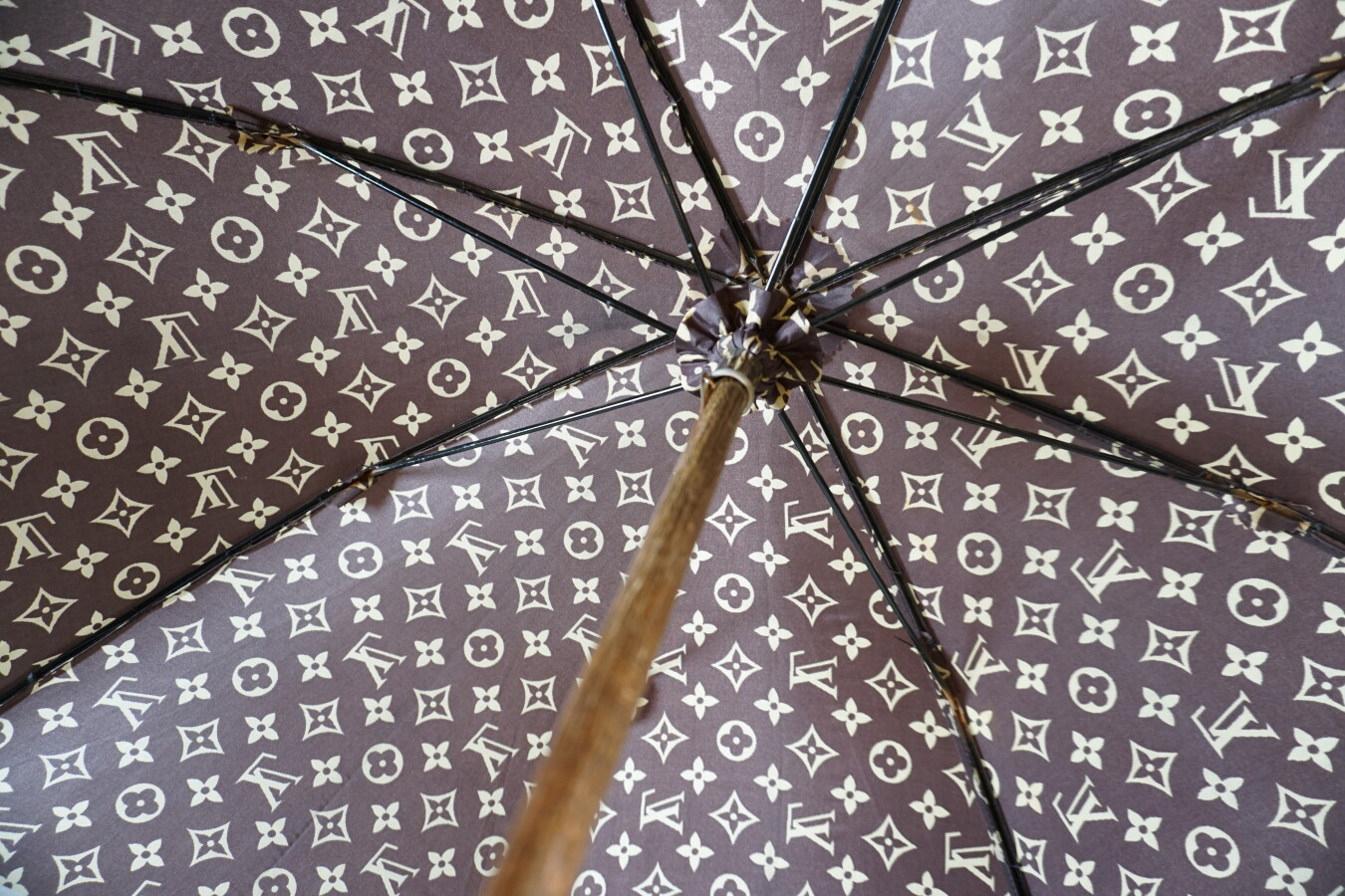 Louis VUITTON : Parapluie en toile Monogram, poignée en résine ambrée, L.  75 cm.